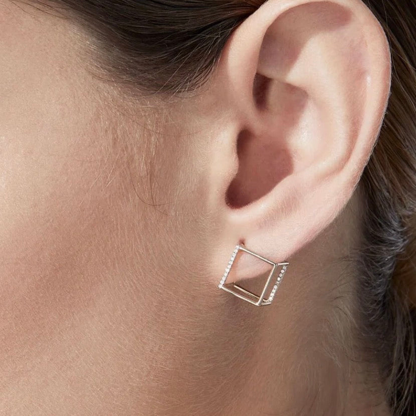18k solid gold diamond 3D cube earring worn on model's ear, yellow gold pavé diamond geometric earring

