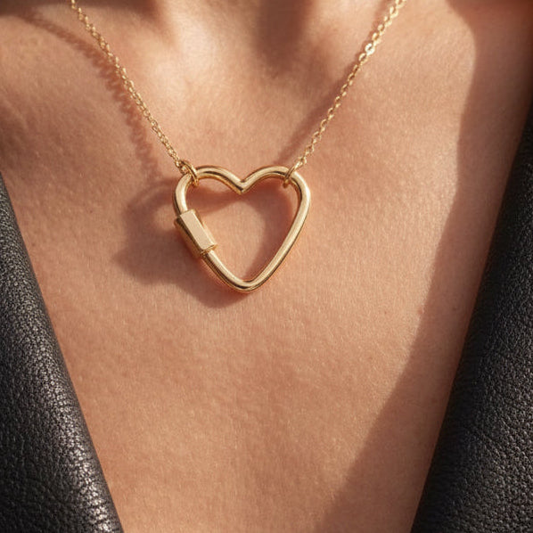 14k solid gold heart carabiner charm holder in yellow gold, heart-shaped screw clasp necklace connector, on model
