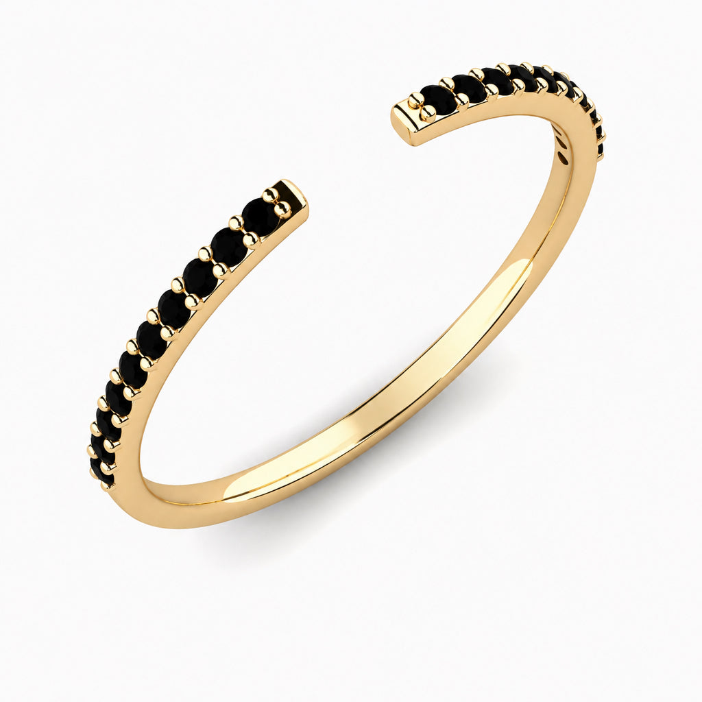 Angle view of a yellow gold black pavé diamond open stack ring, showing the gap and diamond-set shoulders.
