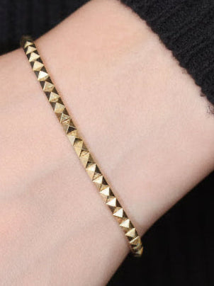 14k solid gold pyramid bracelet on wrist, geometric pyramid studs in yellow gold
